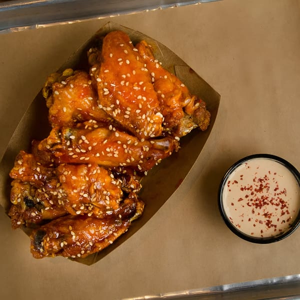 Harold's Chicken Shack #30 fried chicken wings with sesame seeds and dipping sauce.