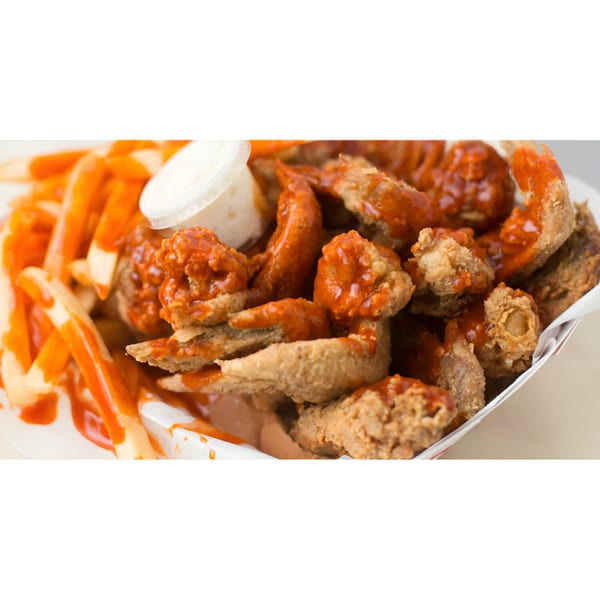 Harold's Chicken Shack #30 fried chicken wings and fries, drizzled with hot sauce and a side of ranch.