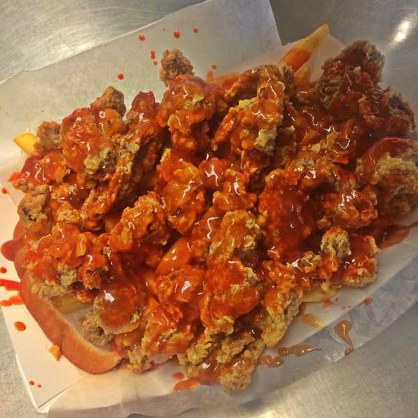 Harold's Chicken Shack #30 fried chicken and fries smothered in hot sauce on a bun.