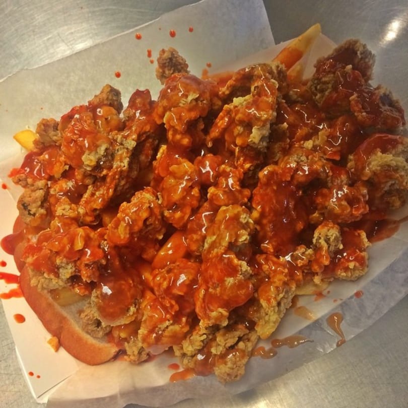 Harold's Chicken Shack #30 fried chicken and fries smothered in hot sauce on a bun.